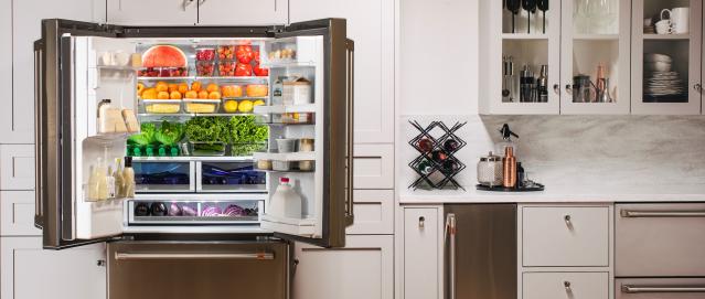 Refrigerator with doors open and a rainbow of groceries inside