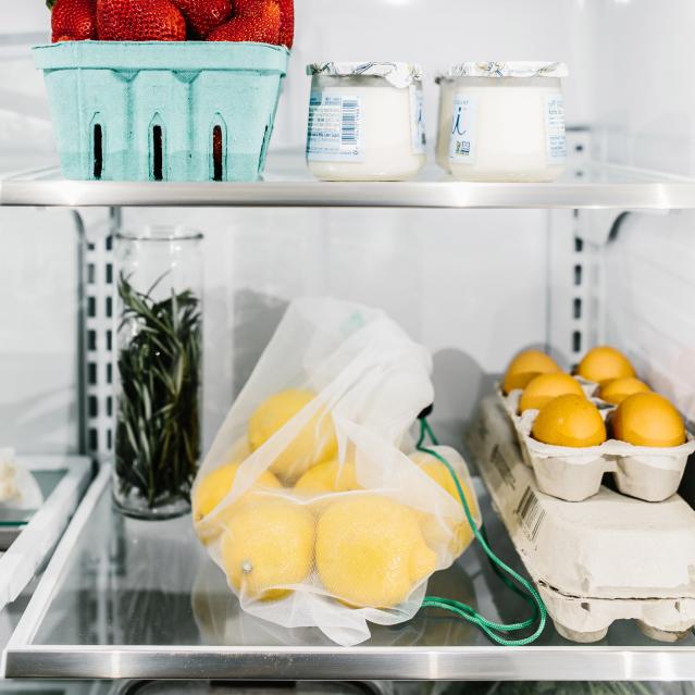 reusable product bags and glass food containers in refrigerator
